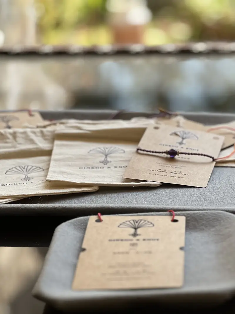 Blessing cards and stamped cotton pouches laid out on the packing table.